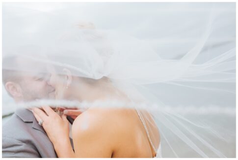 bride and groom kiss, veil blowing, port huron wedding, marysville beach wedding